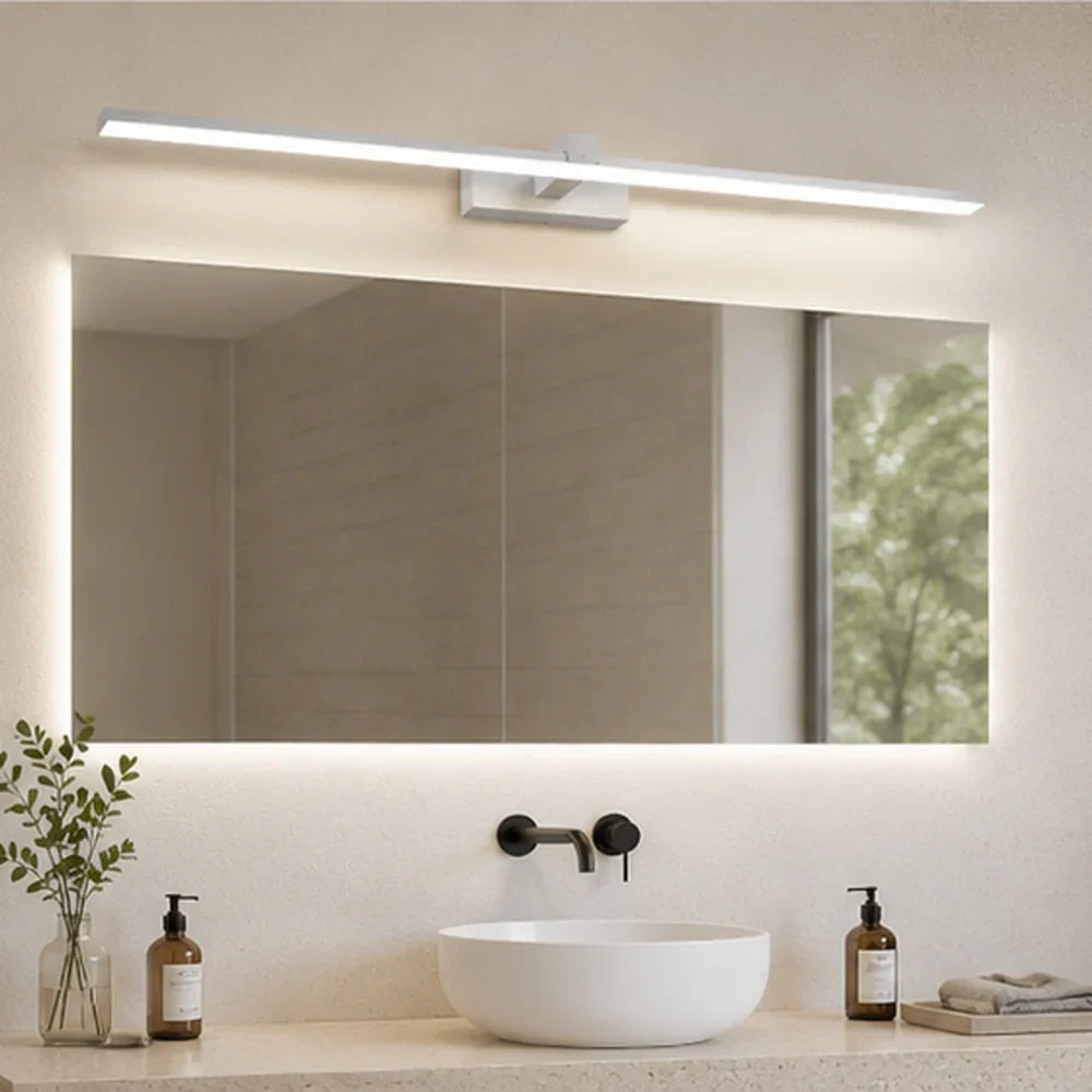 Applique murale salle de bain Rive blanche au-dessus d’un miroir lumineux dans une salle de bain minimaliste.