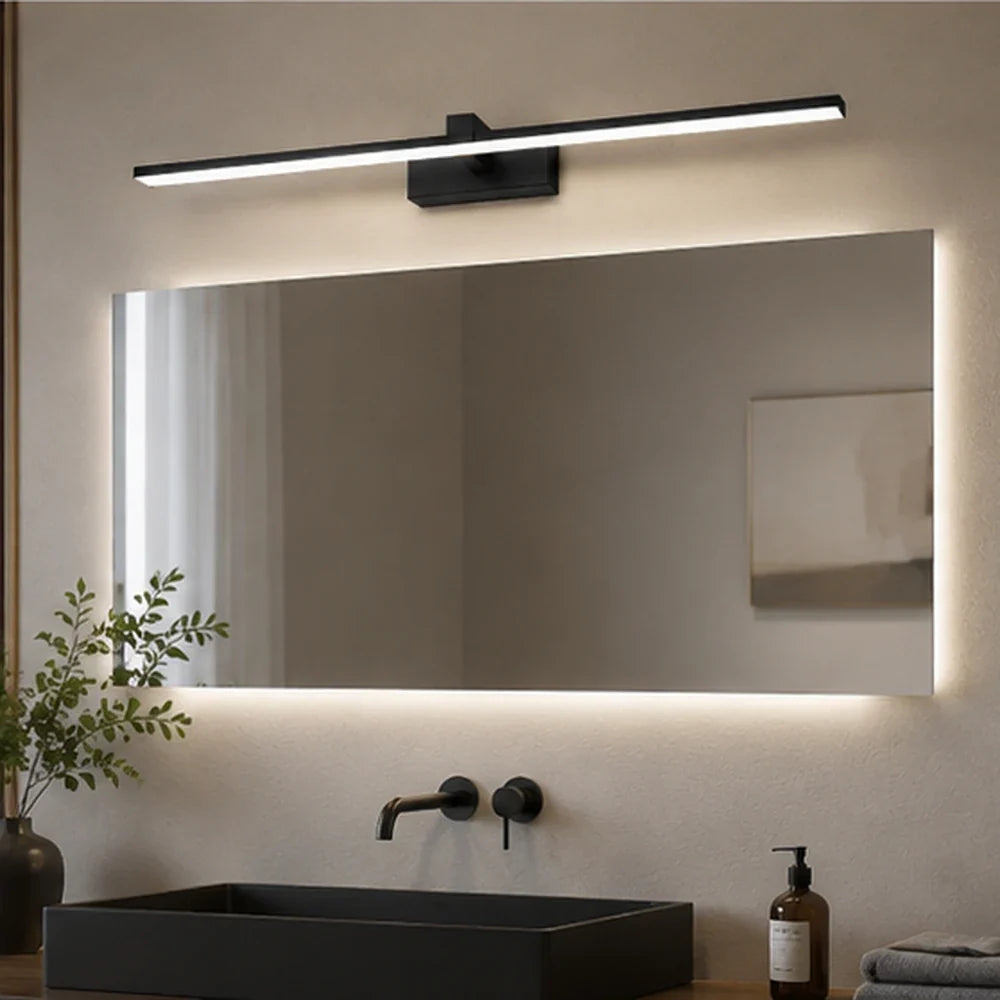 Applique murale salle de bain Rive noire au-dessus d’un miroir dans une salle de bain moderne aux finitions minérales.